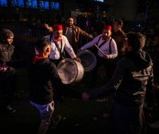A group of men are playing drums in a dark room.