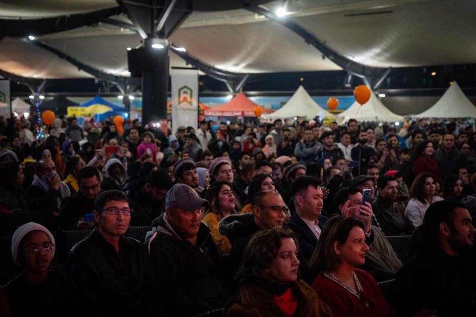 A crowd of people are sitting in a theater watching a movie.