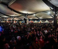 A large crowd of people are sitting in a large room.