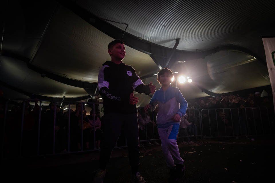 A man and a child are dancing in a dark room.