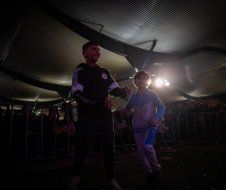 A man and a child are dancing in a dark room.