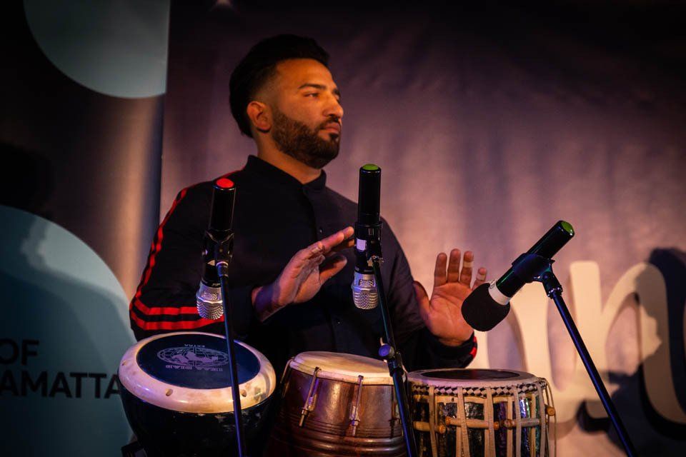 A man is playing drums and singing into a microphone.
