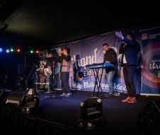A group of people are standing on a stage playing instruments.