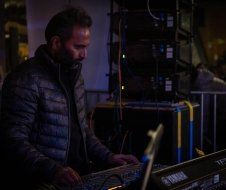 A man is playing a keyboard in a dark room.