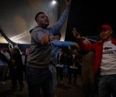 A group of people are dancing in a dark room.
