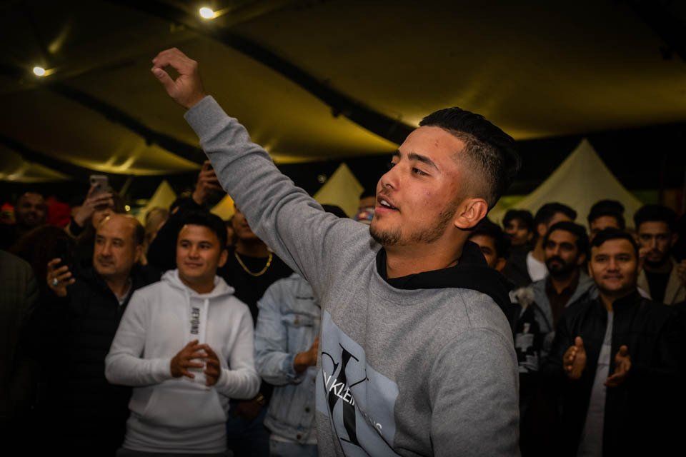 A man is dancing in front of a crowd of people at a party.