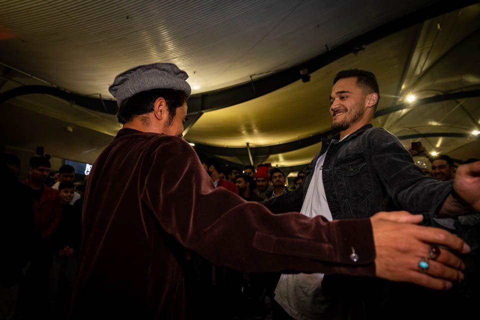Two men are dancing together in a dark room.