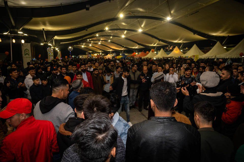 A large group of people are standing in a room.