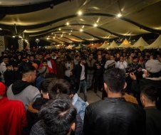 A large group of people are standing in a room.