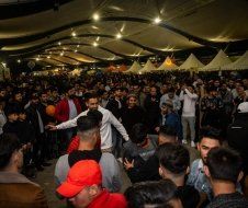 A large group of people are dancing in a room.