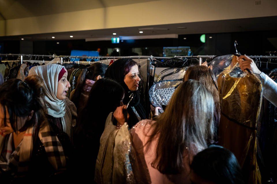 A group of women are shopping for clothes in a store.