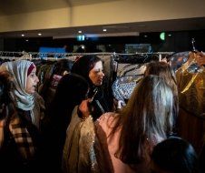 A group of women are shopping for clothes in a store.