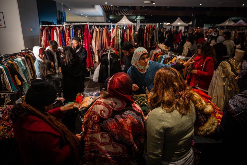 A crowd of people are shopping at a flea market.