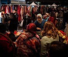 A group of people are standing around a clothing store.