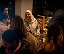 A woman in a hijab is standing in a crowd of people.