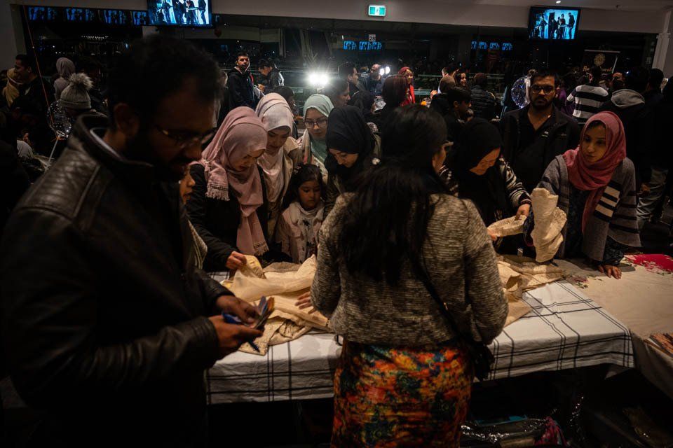 A group of people are standing around a table with a mummy on it.