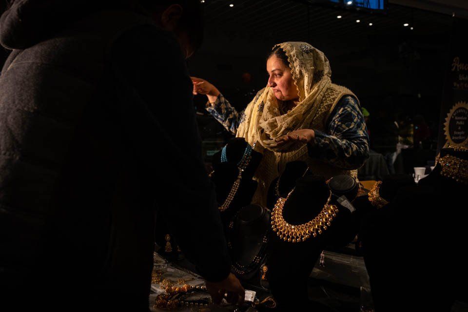 A woman wearing a scarf is standing in a dark room.