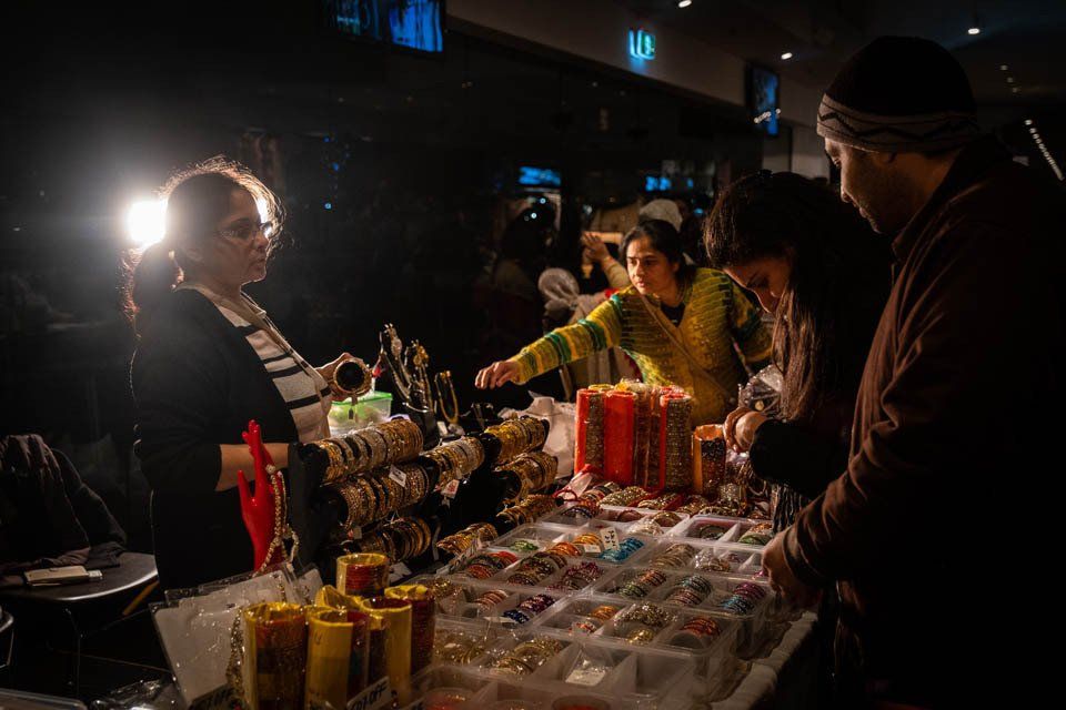 A group of people are standing around a table looking at candles.