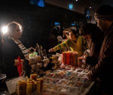 A group of people are standing around a table looking at candles.