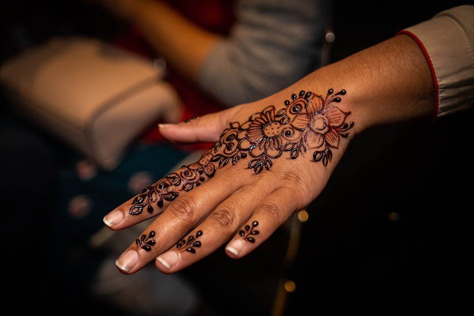 A close up of a woman 's hand with a henna tattoo on it.