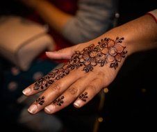 A close up of a woman 's hand with a henna tattoo on it.