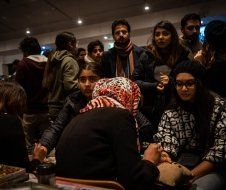 A group of people are sitting around a table in a room.