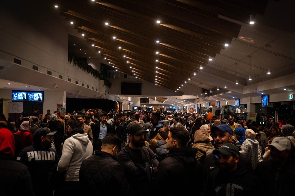 A large crowd of people are gathered in a large room.