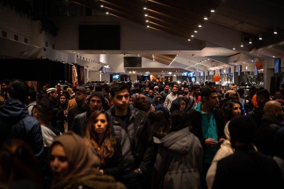 A crowd of people are standing in a dark room.