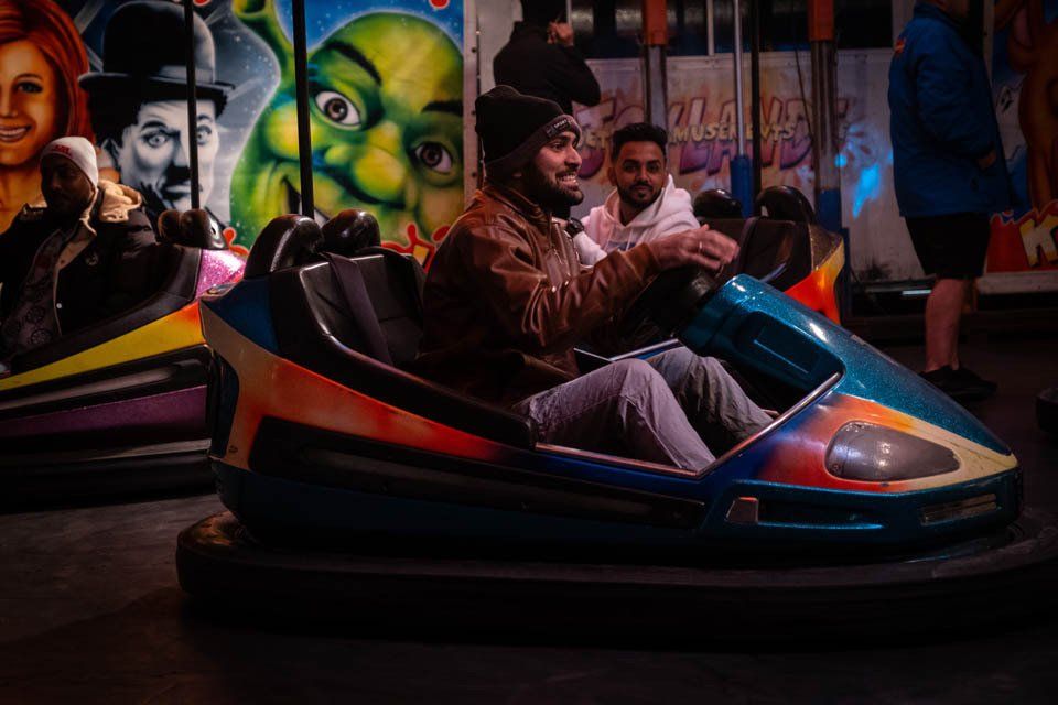 A man is riding a bumper car at an amusement park.