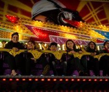 A group of people are riding a roller coaster at an amusement park.