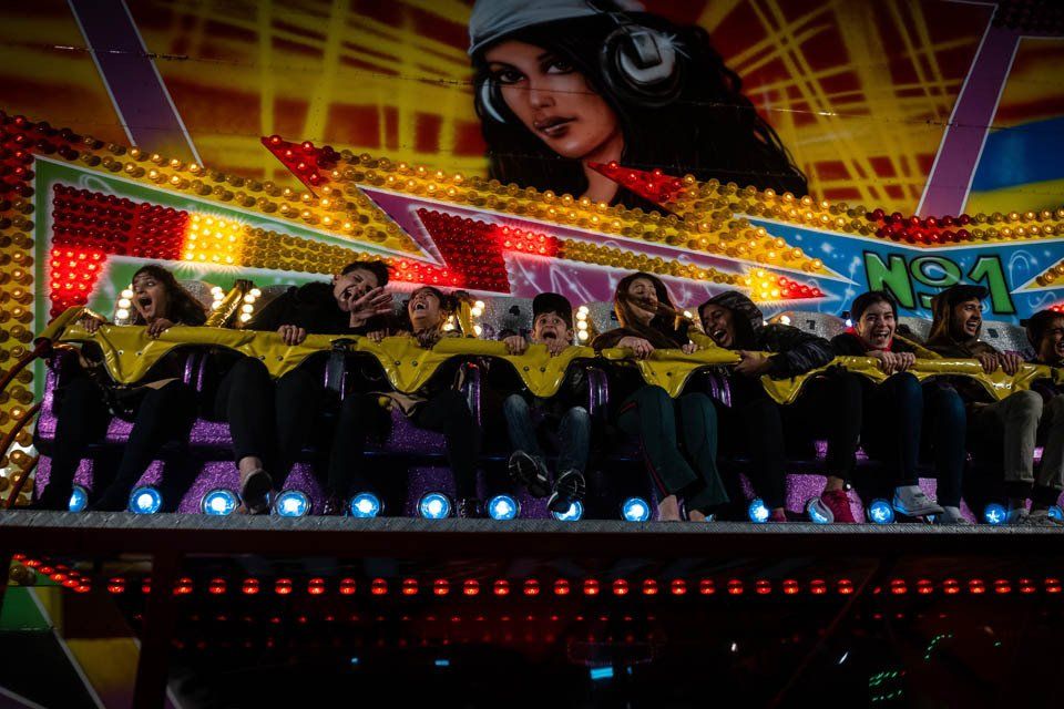 A group of people are riding a roller coaster at an amusement park.