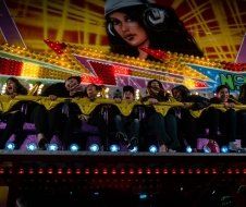 A group of people are riding a roller coaster at an amusement park.