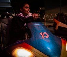 A woman is riding a carnival ride at night.