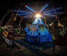 A group of people are riding a carnival ride at night.