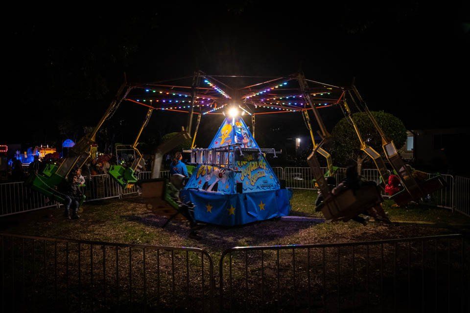A group of people are riding a carnival ride at night.