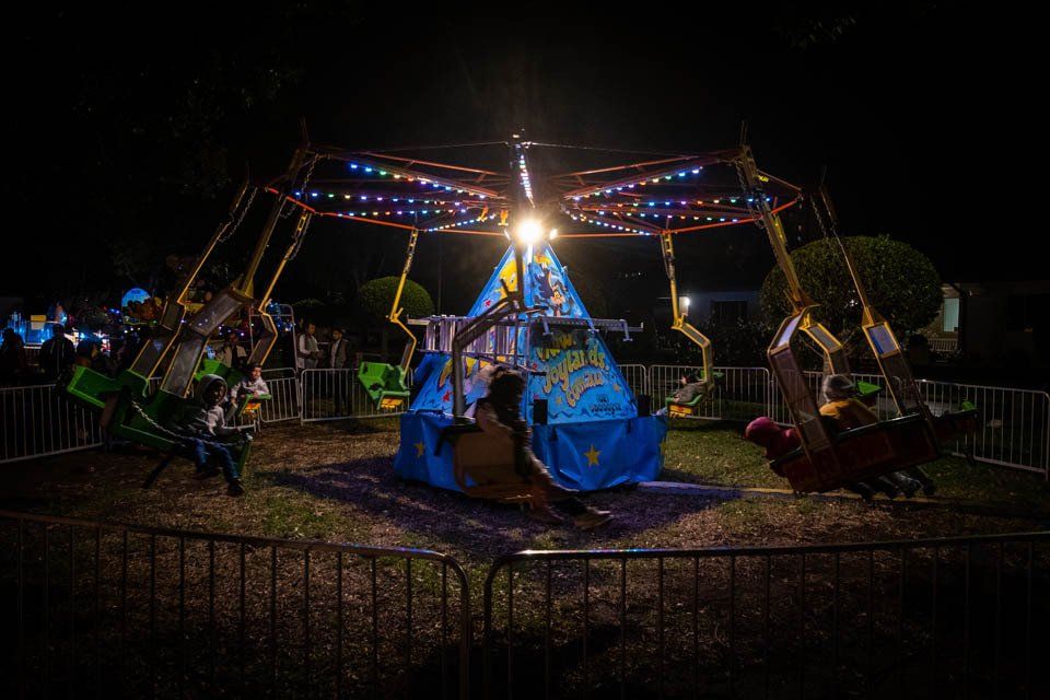 A group of people are riding a carnival ride at night.