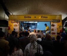A group of people are standing in line at a food truck.