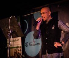 A man is singing into a microphone on a stage.