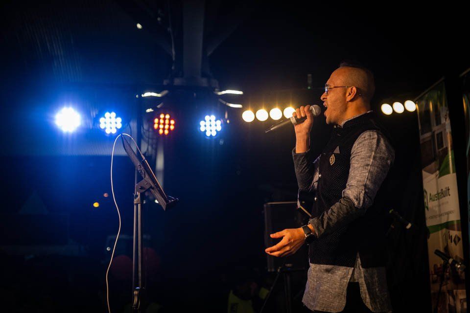 A man is singing into a microphone on a stage.