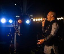 A man is singing into a microphone on a stage.