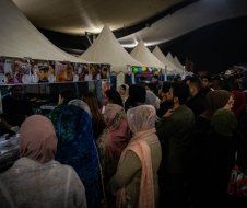 A group of people are standing in a line at a food festival.