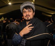 A man with a beard is wearing a hat and a scarf.