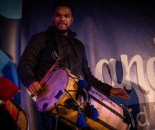 A man is playing a drum in a dark room.