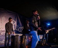 A man is standing on a stage holding a microphone.