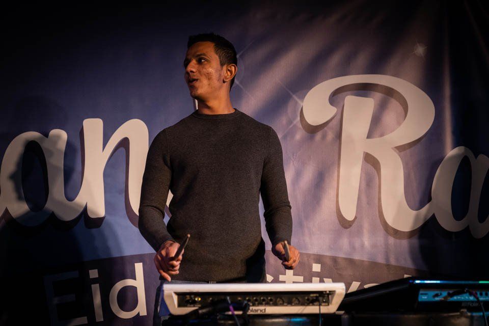 A man is standing in front of a sign that says an r.