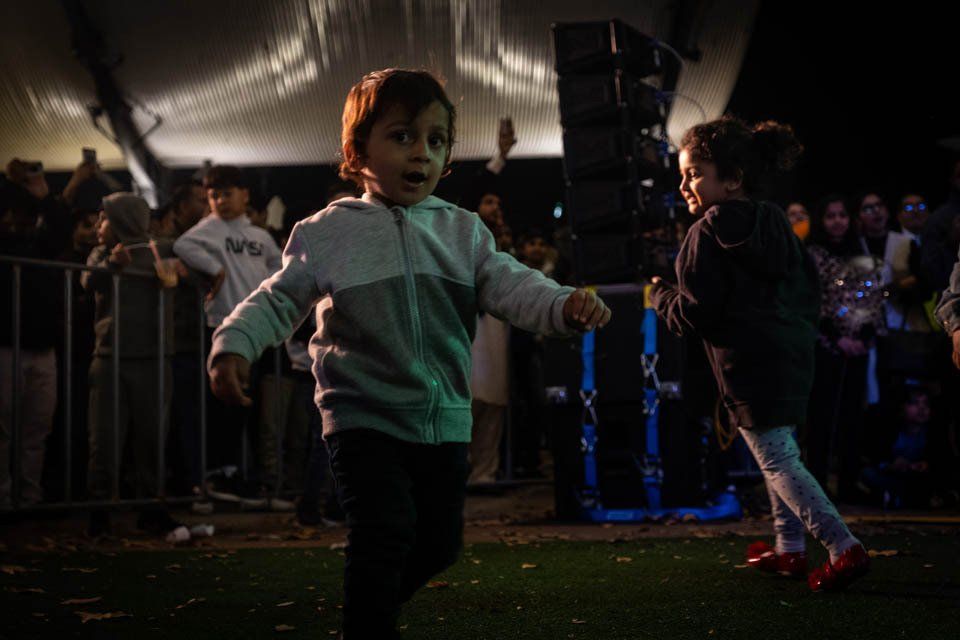 A boy and a girl are dancing in front of a crowd.