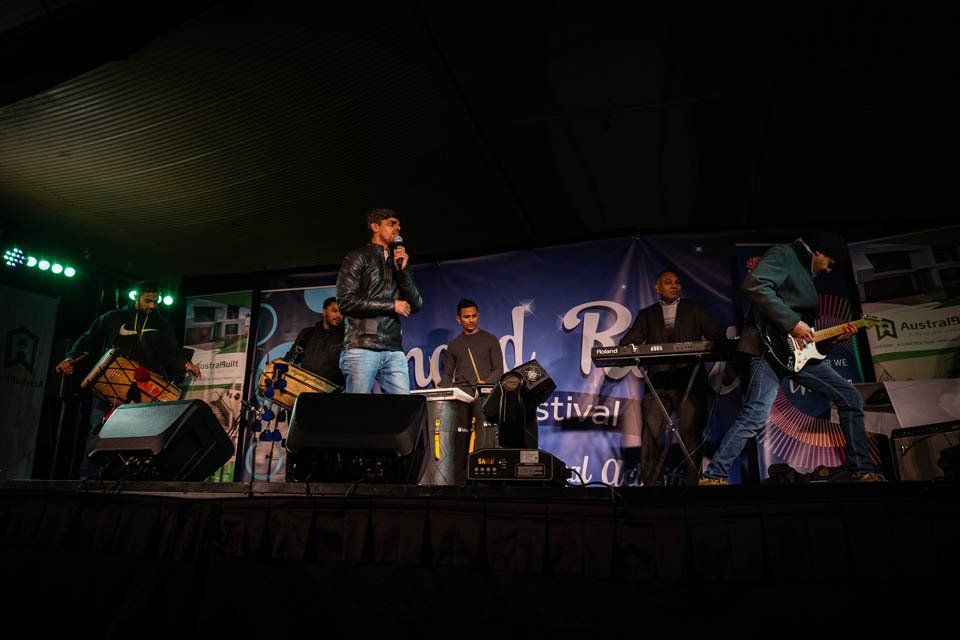 A group of people are standing on a stage playing instruments.