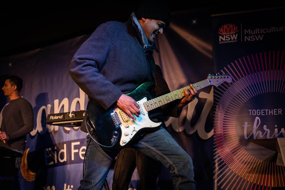 A man is playing a guitar on a stage.