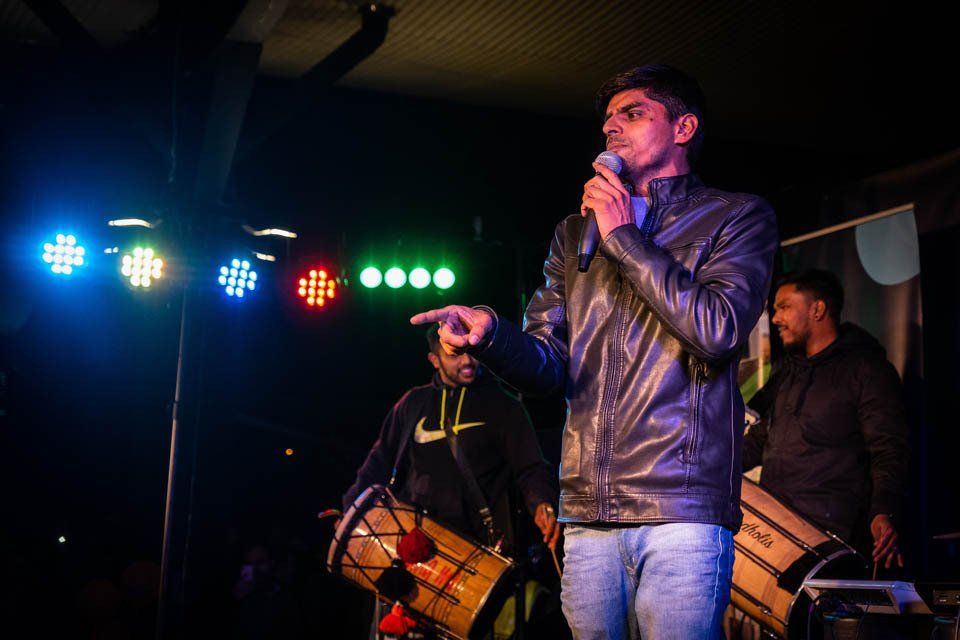 A man is standing in front of a microphone on a stage.