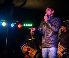 A man is standing on a stage holding a microphone.